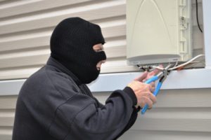 Photo of burglar cutting phone line